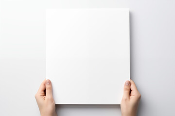 A hand holding a blank white canvas, used for mockup