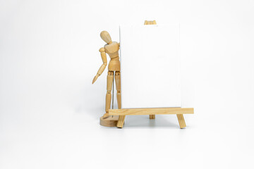 Wooden doll with empty easel on white background; business or creative concept