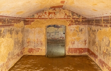 Frescoes in ruins inside ancient etruscan tomb