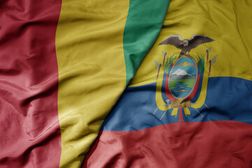big waving national colorful flag of ecuador and national flag of guinea .