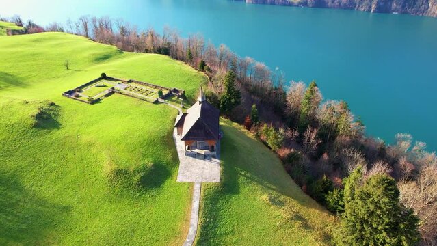 A beautiful lakeside house nestled in the rolling hills. The house is Aerial view of a lakeside house nestled in the hills. The house is surrounded by trees and shrubs, and the lake is calm and serene