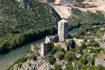Fototapeta premium Gavran-Kapetanovic tower in medieval town Počitelj on bank of Neretva river during sunny day