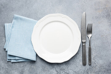 Empty white plate and cutlery and table cloth. Table setting, top view, copy space for design or text