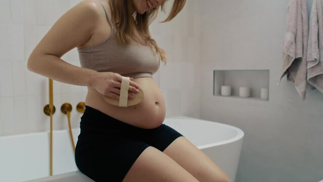 Pregnant woman doing dry body brushing