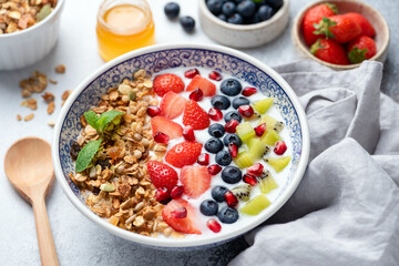 Granola bowl with berries, pomegranate and kiwi. Healthy superfood breakfast bowl