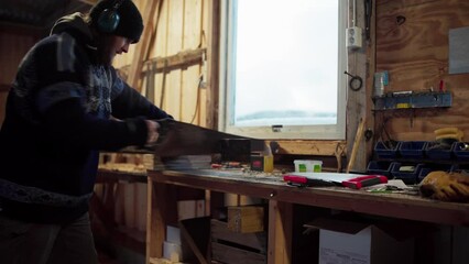 A Man is Using a Saw to Cut Lumber Manually - Static Shot