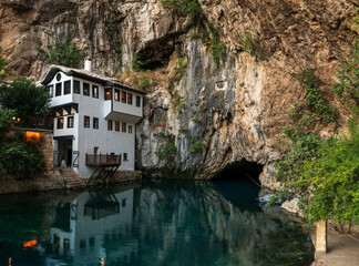 Fototapeta na wymiar Blagaj tekke and Buna river source at foot of stone cliff. Dervish tekke near Mostar