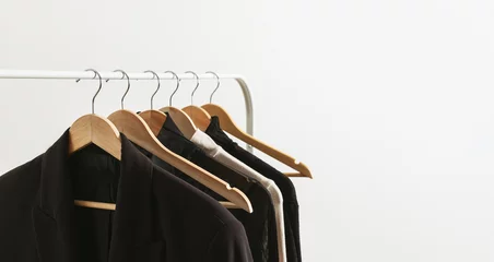 Modern rack with capsule collection in neutral black and beige colours. Beautiful minimalistic lifestyle banner with copy space for your text.. © Nika Votinova