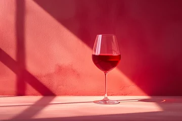 Fotobehang Glass of red wine casting shadows on a textured surface © agnes