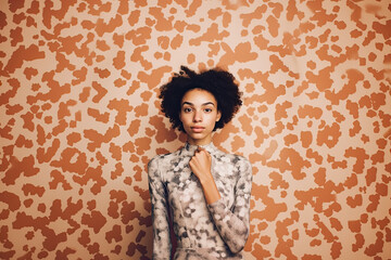 Fototapeta premium Wild Visions: A Femme Fatale Stands Her Ground Before a Ferocious Leopard Print Wall