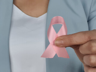 Female hands holding a pink breast cancer awareness ribbon