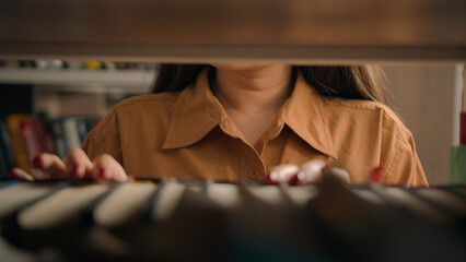Close-up unrecognizable woman teacher girl student female customer bookworm browsing bookcase...