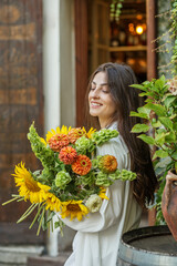Fototapeta premium Content Woman with a Bouquet of Seasonal Flowers