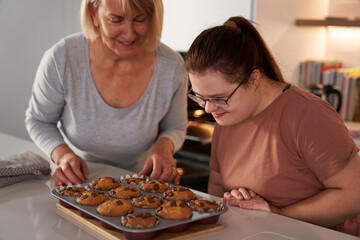 Down syndrome woman and mother about to eat homemade cupcakes