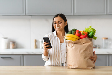 Cheerful young indian woman order grocery online