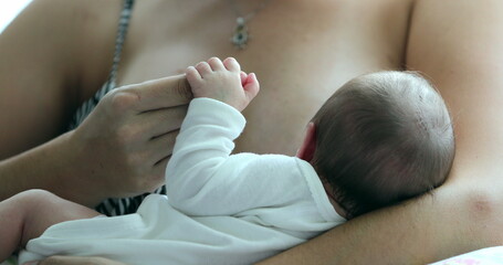 Mother holding newborn baby in her arms holding little finger