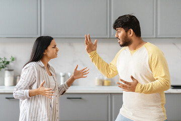 Emotional young indian couple fighting at kitchen