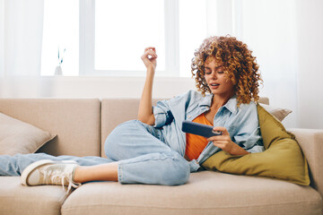 Relaxing on the Couch: A Smiling Woman Holding a Mobile Phone in a Cozy Living Room