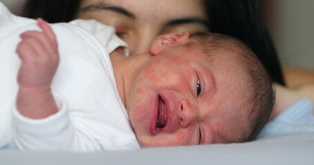 Mother next to newborn baby laying in bed