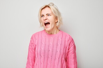 Portrait of girl screaming with anger, freaking out, breakdown on white background. Depression,...