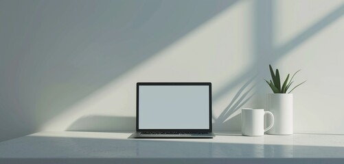 Minimalistic scene with a rectangular form laptop near an empty white mug for simplicity.