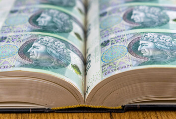 A book with Polish 100 zl banknotes in place of pages