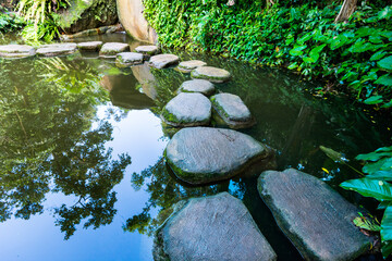Stepping stones path over a pond - Powered by Adobe