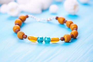 amber beaded necklace on a contrasting cyan surface