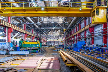 Machines, metal sheets, metal profiles, pipe in selective focus on a metal structures plant.Machine tools and mechanisms, steel press on a metallurgical factory. Industrial background.