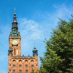 Tower of Main City Hall on Dluga street in the old city center of Gdansk, Poland. ClockTower built in 14th century. A walk through the city on a sunny summer day - obrazy, fototapety, plakaty