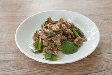 spicy stir fried slice  beef meat with basil leaf and dry chili on plate 