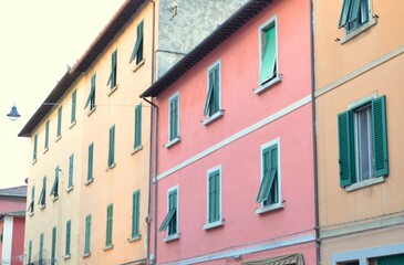 Facades of houses of different colors with windows.
