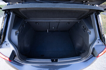 Rear view of the car open trunk. Modern hatchback car with open empty trunk. The car boot is open for luggage. A lot of space for coffers and bags. Ready for a trip.