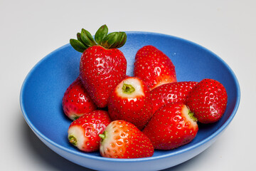 Strawberries in a plate on a table ready to be eaten.