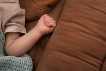 A child's hand on the bed. 
The concept of health care and welfare. The concept of fostering and adoption.