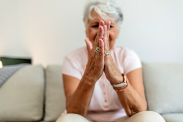 Senior Caucasian woman rubbing her hands in discomfort, suffering from arthritis in her hand while...