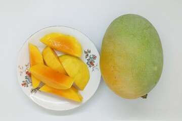 Mango fruit (Mangifera indica) which is cut into several thick slices, turns yellow as a sign of ripeness and sweetness.