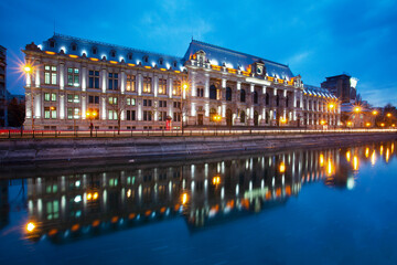 'Palace of Justice' built on the shores of the Dambovita River illuminated at dusk