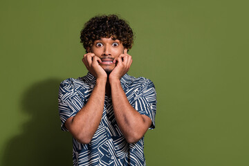 Photo of scared frightened man dressed print shirt hands arms cheeks cheekbones empty space isolated green color background