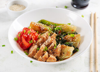 Stir fried of chicken, sweet peppers and bok choy in a bowl on the table. Stir fry pak choi. Asian food.