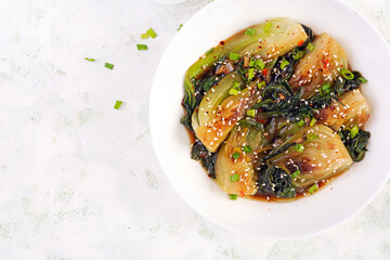 Homemade asian sauteed soy bok choy with sesame seeds. Stir fry pak choi. Asian food. Top view - obrazy, fototapety, plakaty