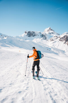  A man on ski alpine tour throught snowy Alps in Switzerland or Austria, Backcountry skier in Alps