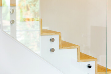 Staircase covered in oak parquet with tempered glass balustrade and chromed pins.