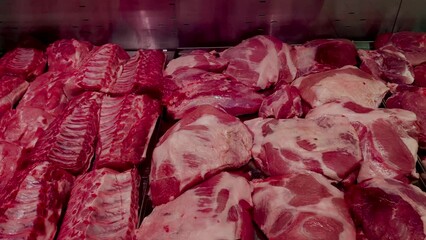 Large selection of fresh raw meat in supermarket refrigerator for sale.