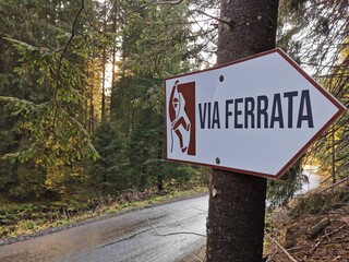 A vibrant white and red street sign stands on the roadside, guiding drivers with its clear and bold messaging.