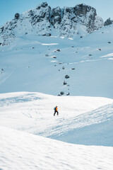 Naklejka na ściany i meble A man on ski alpine tour throught snowy Alps in Switzerland or Austria, Backcountry skier in Alps