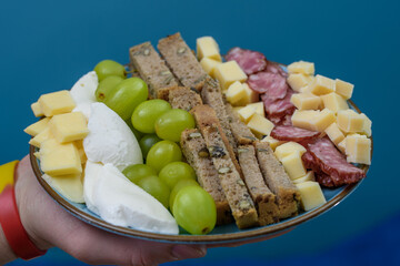 Talerz serów z owocami i wędlina w formie szwedzkiego stołu 