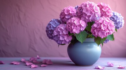  a blue vase filled with pink and purple flowers on a purple tablecloth with petals scattered on the floor and a pink wall behind the vase with a pink wall in the background.