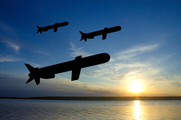 Silhouettes of Tomahawk cruise missiles against the sunset