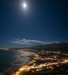 Aerial drone view of roda beach by night in corfu, Greece with full moon